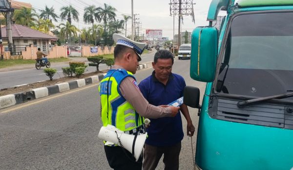 Saat petugas Polantas Polres Lhokseumawe membagikan brosur kepada sopir angkutan umum di jalanan. Foto: Humas Polres Lhokseumawe.