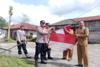 Waka Polsek Permata Ganti Bendera Merah Putih Yang Telah Usang Dengan Bendera Merah Putih Baru
