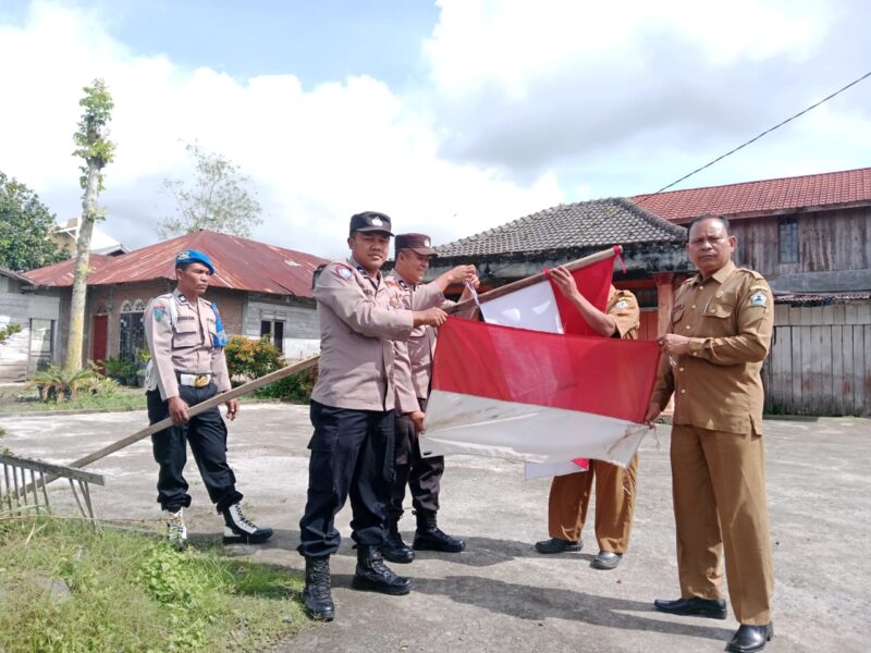 Waka Polsek Permata Ganti Bendera Merah Putih Yang Telah Usang Dengan Bendera Merah Putih Baru
