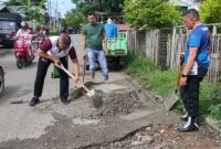 Personel Polsek Kuta Raja turun tangan memperbaiki jalan rusak dan berlubang atau rusak di gampong Lampaseh Kota, Banda Aceh, Jumat (1/12/2023). 