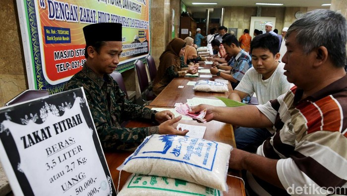 Ilustrasi orang membayar zakat melalui amil zakat 