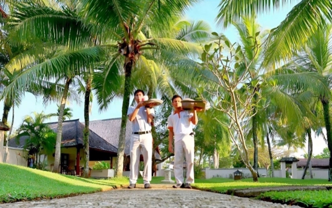 Pegawai Hotel Tanjung Lesung Resort di Pandeglang sedang mengantarkan pesanan wisatawan yang tengah berlibur. (Instagram/@tanjunglesung.resort)