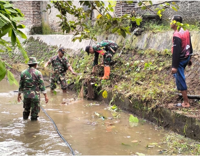 Sejumlah personel TNI dari Koramil 0106/Menes bersama warga, tengah membersihkan sampah yang ada di aliran sungai Kampung Kampung Kupa Handap. (Dok. Kodim 0601 Pandeglang)