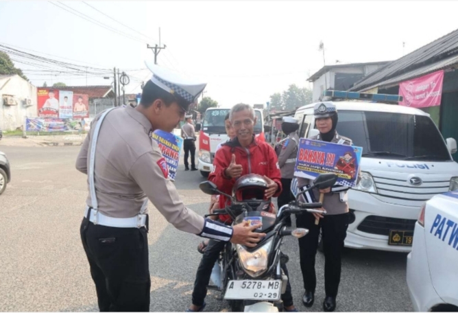 Seorang pengendara mendapat helm gratis dalam Pelaksanaan Operasi Patuh Maung 2024 di Lebak Lebak (Foto: TLii/Heru)