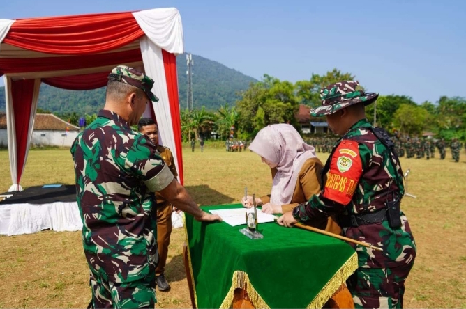 Bupati Pandeglang, Irna Narulita menandatangani berita acara dimulainya kegiatan TMMD di Desa Cikumbueun, Kecamatan Mandalawangi. (Foto: Dok. Kodim 0601 Pandeglang)