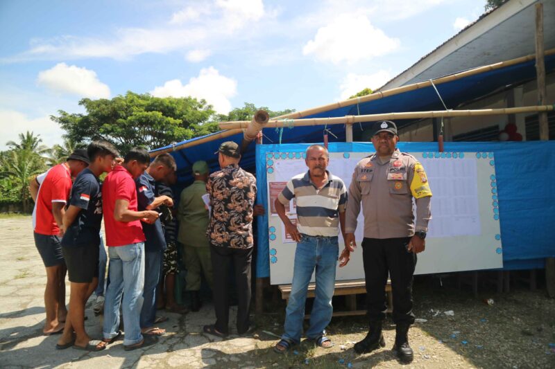 Babinkamtibmas Desa Pandayora, Aiptu Stepanus, turut serta dalam mengawal jalannya proses pemungutan suara di Tempat Pemungutan Suara (TPS) pada pemilihan umum yang berlangsung (Rabu 27/11). FOTO : Stenlly Ladee 