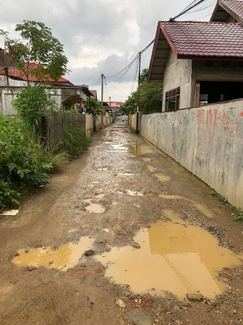 Kondisi jalan yang bergelombang dan becek di Uteunkot, Lhokseumawe, setelah hujan.