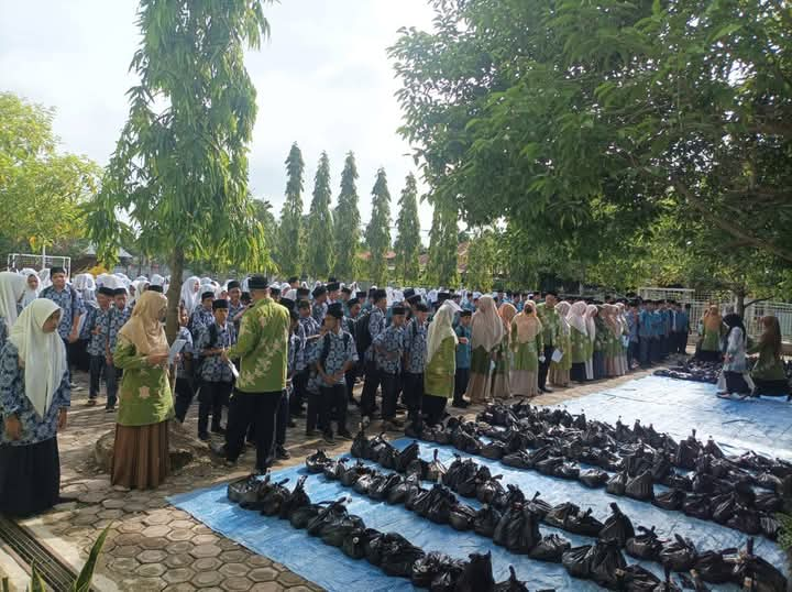 Kepala MTsN 4 Pidie Jaya, Imran, S.Pd.i,.M.Pd, Membagikan sembako kepada para Siswa-Siswi di halaman sekolah,  rabu (26/2/2025) foto.Ist