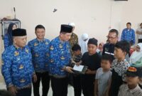 Bupati Tgk H Sibral Malasyi MA, di damping Kadissos P3A Agusmaidi, SIP,M.M, Menyerahkan Santunan Anak yatim, di Aula Kantor Camat Bandar Dua,Senin (17/03/2025)